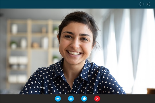 Woman taking an online class, smiling on monitor