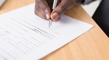 A man signs a contract.