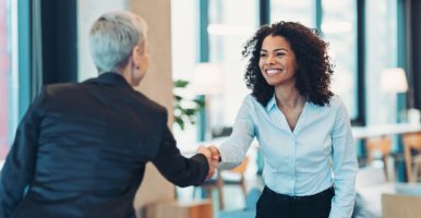 Poignée de mains entre entrepreneurs lors d’une réunion avec des collègues.