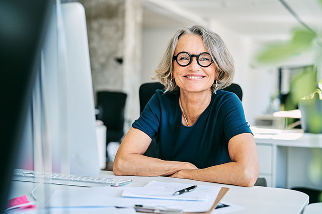 A happy mature businesswoman working in a business office.