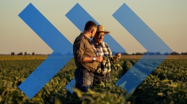Agricultural professionals discussing crops in a lush field at sunset, symbolizing growth and progress with forward-moving blue arrows