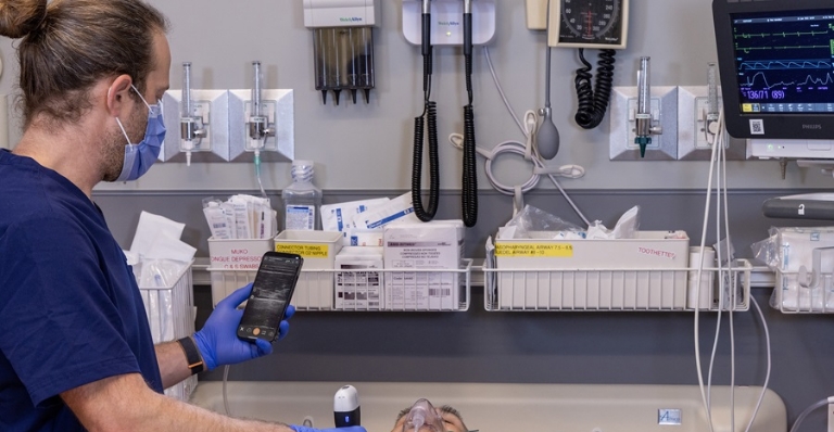 Medical staff using Clarius ultrasound device to check patient lungs in hospital