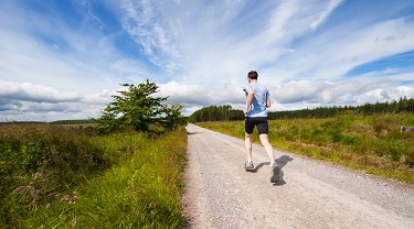 Un homme court sur un sentier.