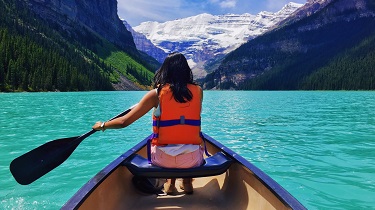 Female paddles in canoe on Moraine Lake