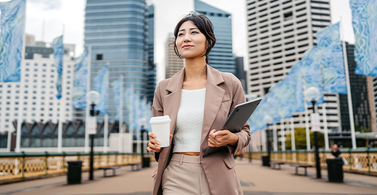 Business professional carrying laptop in an urban business district, reflecting exporter confidence and growth.