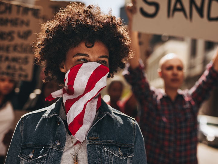 Woman leads protest wearing mask.