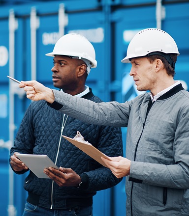 Two exporters discuss shipment in front of container