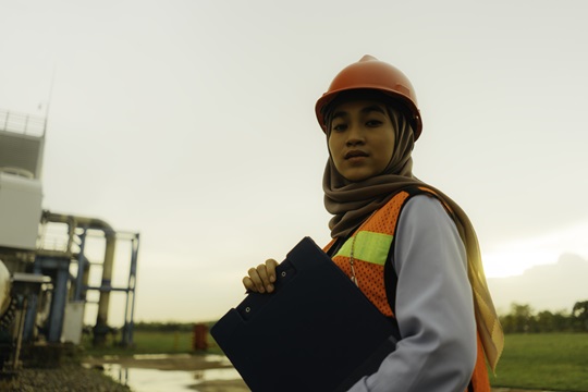 An individual in the Philippines a safety vest holding a folder on an energy producing site