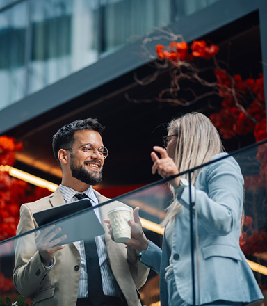 Colleagues discussing business financing for exporters on an office balcony.