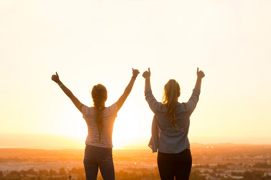 Deux jeunes femmes donnant un pouce en l’air au ciel