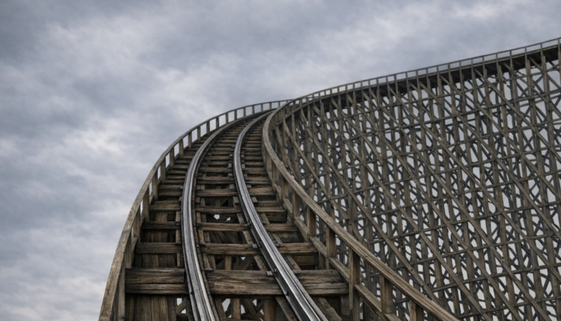 Wooden rollercoaster track stretches upward into a dark, gloomy sky.