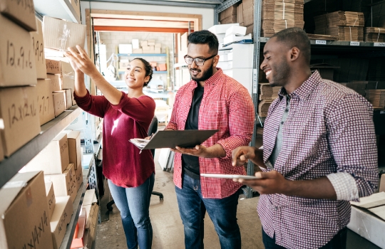 Deux hommes et une femme faisant l'inventaire de leur stock.