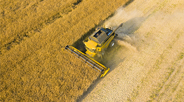 Farming machinery working in a large field.