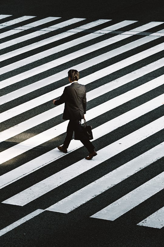 Un homme d’affaires marchant sur une route striée