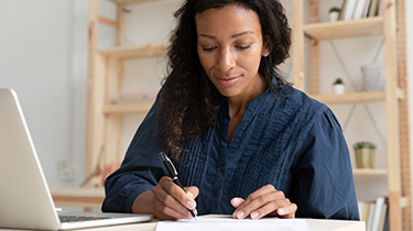 A business woman is working at her desk reviewing business documents.