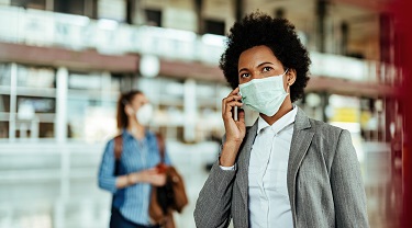 A business woman wears a mask