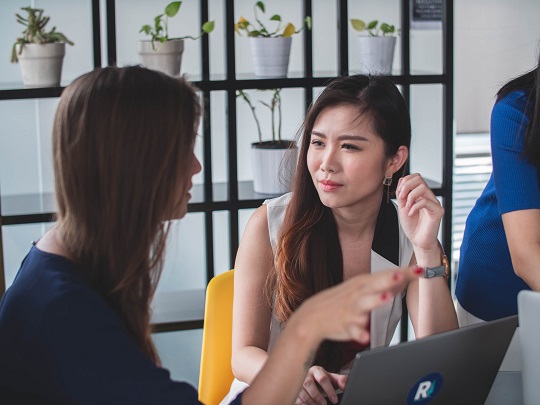 Two women discuss business